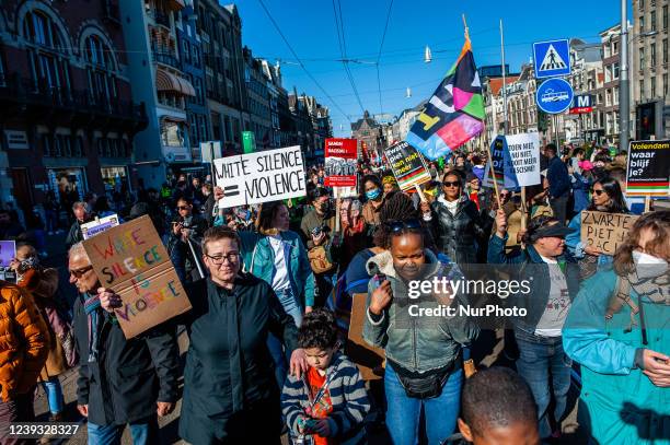 Hundreds of people are walking while holding placards, during the demonstration against racism in Amsterdam, on March 19th, 2022.
