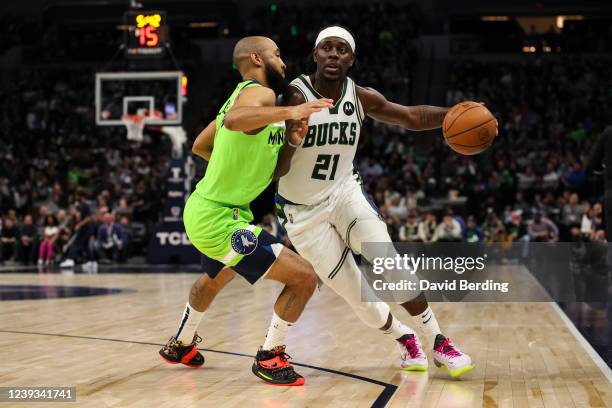 Jrue Holiday of the Milwaukee Bucks dribbles the ball while Jordan McLaughlin of the Minnesota Timberwolves defends in the third quarter of the game...