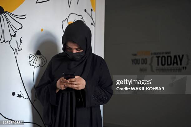 In this photo taken on February 14 computer science student Forozan Faqiri checks her cryptocurrency account on her smartphone in Herat. - Since the...