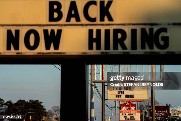 Now Hiring signs are displayed in front of restaurants in Rehoboth Beach, Delaware, on March 19, 2022.