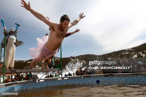 Teammates bellyflop into a pool of frigid water while competing in the Polar Plunge during Frozen Dead Guy Days on March 19, 2022 in Nederland,...