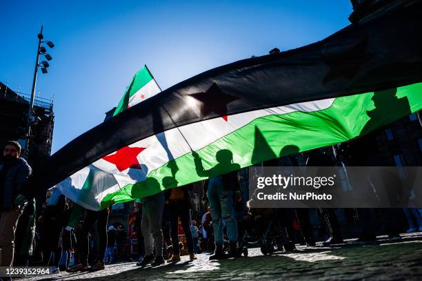 Syrian people are holding Syrian flags, during a demonstration Eleven Years of the Syrian Revolution, organized in Amsterdam, on March 19th, 2022.