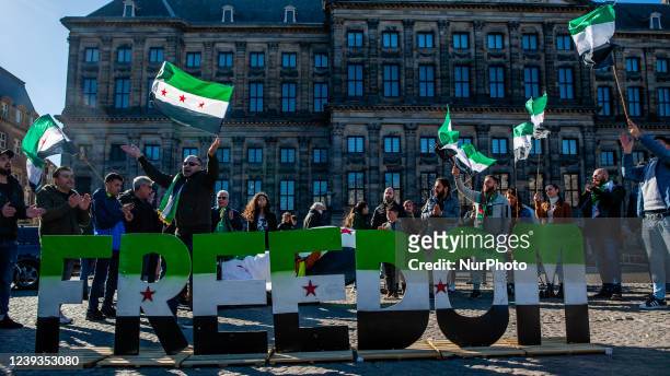 Syrian people are holding Syrian flags, during a demonstration Eleven Years of the Syrian Revolution, organized in Amsterdam, on March 19th, 2022.