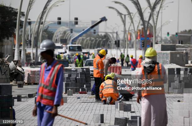 March 2022, Qatar, Doha: Construction workers renew paths in downtown Doha. Numerous streets are currently being redesigned in the run-up to the...