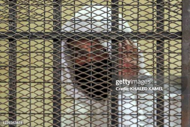 Egyptian media and real estate tycoon Mohamed el-Amin looks from the defendant's cage during a trial session over charges of "human trafficking" and...
