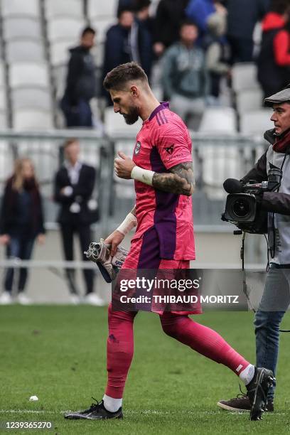 Bordeaux's French goalkeeper Benoit Costil leaves the field at the end of the match under booing and insults from the Bordeaux supporters following...