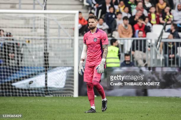 Bordeaux's French goalkeeper Benoit Costil leaves the field at the end of the match under booing and insults from the Bordeaux supporters following...