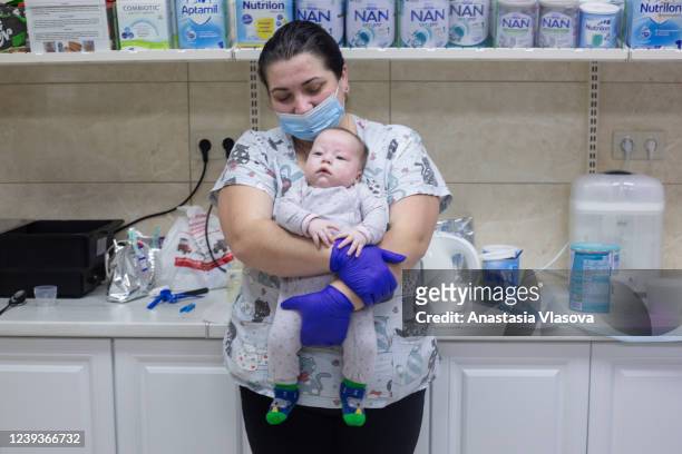 Antonina nurses a baby on March 20, 2022 in Kyiv, Ukraine. Nearly 20 surrogate-born babies, along with the surrogacy center's nursing staff, live in...