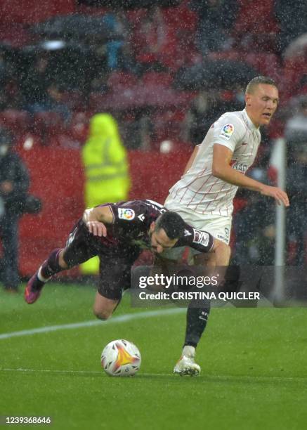 Real Sociedad's Spanish defender Joseba Zaldua falls as he vies with Sevilla's Swedish defender Ludwig Augustinsson during the Spanish League...