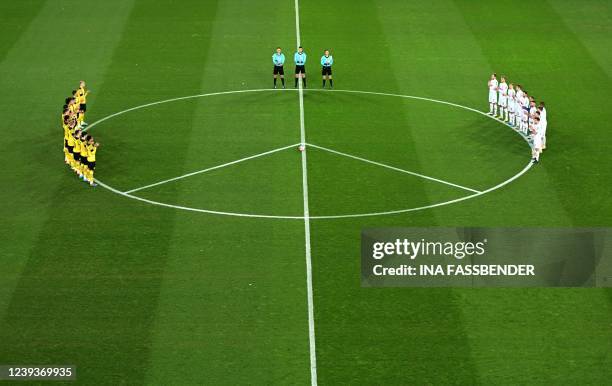 Dortmund's and Cologne's players are seen on the pitch next to a huge peace sign during the German first division Bundesliga football match FC...