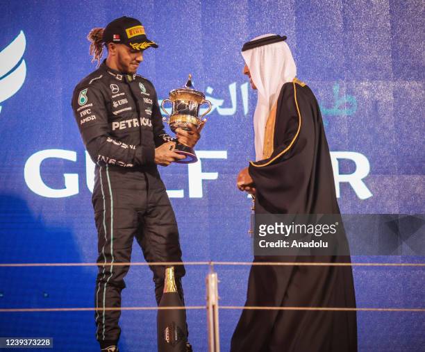 Mercedesâs team British pilot Lewis Hamilton poses with his trophy after winning third place in Bahrain Formula One Grand Prix at the Bahrain...