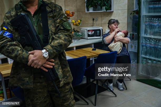 Nursing staff embraces a sleeping baby in a makeshift nursery underground in the outskirts of Kyiv, Ukraine, Sunday, March 20, 2022. More than a...