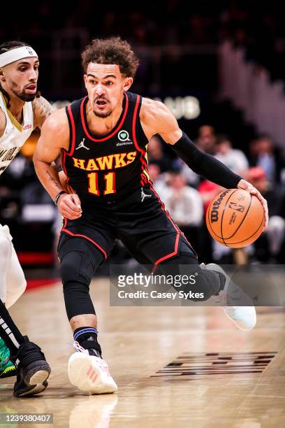 Trae Young of the Atlanta Hawks dribbles as Jose Alvarado of the New Orleans Pelicans defends during the first half at State Farm Arena on March 20,...