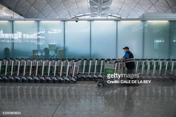 Worker arranges trolleys at Hong Kong International Airport in Hong Kong on March 21, 2022.