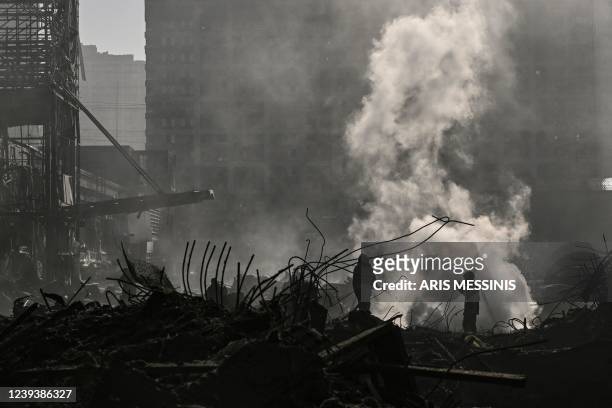 Firefighters douse the fire in the Retroville shopping mall after a Russian attack on the northwest of the capital Kyiv on March 21, 2022. - At least...
