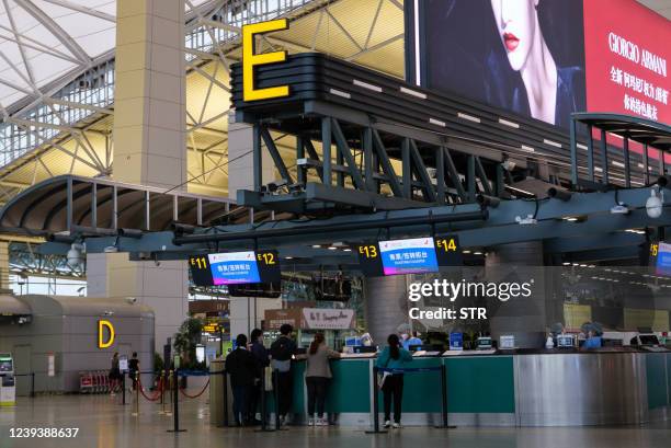 Passengers line up at the check-in counter of China Eastern at Guangzhou Baiyun International Airport in China's southern Guangdong province on March...