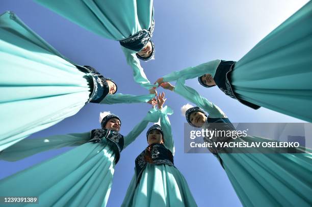 Performers wearing traditional costumes take part in the celebrations of Nowruz at the central Ala-Too Square in Bishkek on March 21, 2022. - Nowruz,...