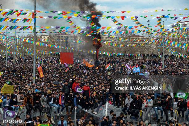 Turkish Kurds gather around a bonfire during Newroz celebrations marking the Persian New Year in Diyarbakir, southeastern Turkey, on March 21, 2022....