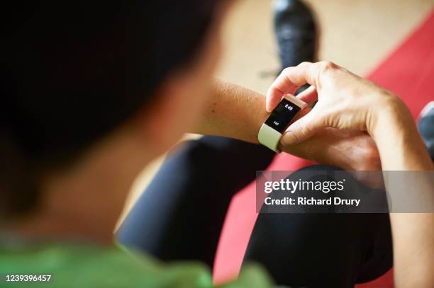 woman exercising in her living room - fitnesstracker stock pictures, royalty-free photos & images