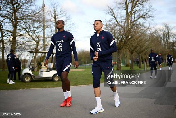 France's mdfielder Paul Pogba and France's forward Kylian Mbappe arrive for a training session in Clairefontaine-en-Yvelines, near Paris on March 21,...