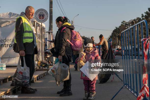 Little girl carries her teddy bear while her mother receives information, they have just crossed the border from Ukraine People seeking refuge in...