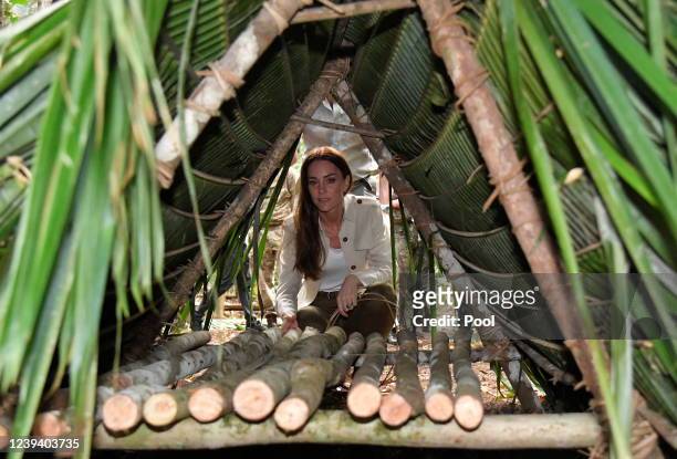 Catherine, Duchess of Cambridge looks at a temporary shelter built from palm trees during a visit to the British Army Training Support Unit jungle...