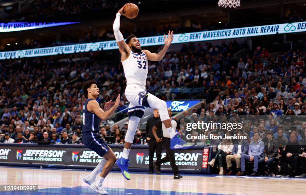 Karl-Anthony Towns of the Minnesota Timberwolves goes up for a slam dunk as Josh Green of the Dallas Mavericks looks on in the first half at American...