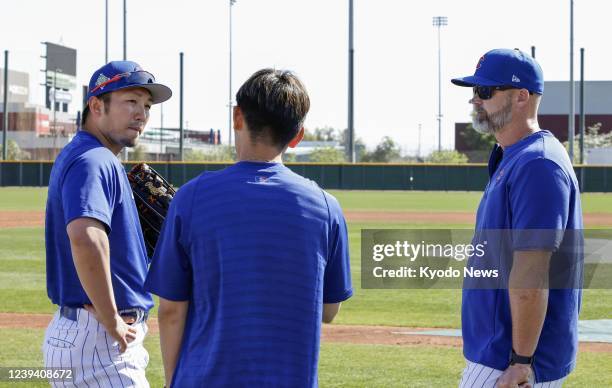 Newly acquired Chicago Cubs outfielder Seiya Suzuki talks with manager David Ross through his interpreter during a spring training baseball workout...