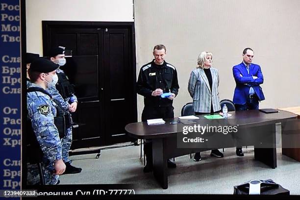 Russian opposition leader Alexei Navalny is seen on a screen via a video link during the verdict in his embezzlement and contempt of court trial at...