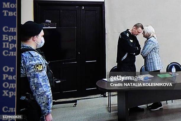 Russian opposition leader Alexei Navalny and lawyer Olga Mikhailova are seen on a screen via a video link during the verdict in Navalny's...