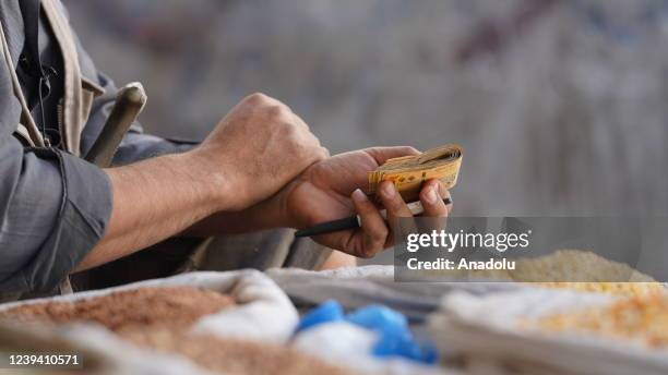 Seller holds money at a market area in Taiz, Yemen on March 10, 2022. The food crisis in Yemen, which is among the poorest countries in the world,...