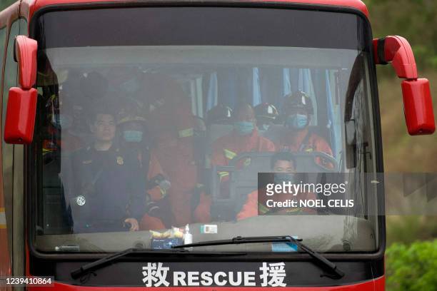 Bus transporting rescue personnel arrives at Fenghuang village in Wuzhou on March 22 near the site where China Eastern flight MU5375 crashed the...