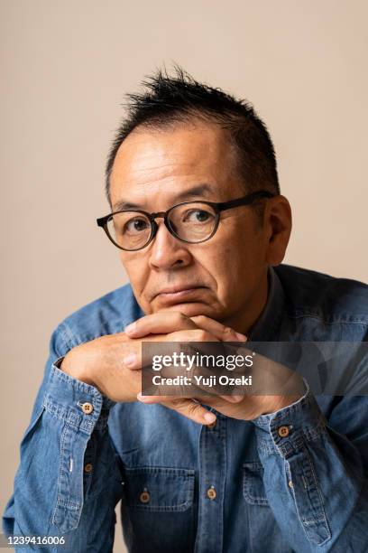 studio portrait of japanese senior man with soft mohawk hair - manquestionmark stock pictures, royalty-free photos & images