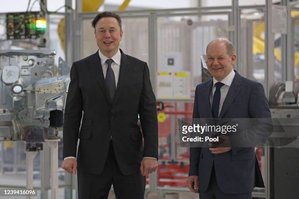 Tesla CEO Elon Musk stands next to German Chancellor Olaf Scholz during the official opening of the new Tesla electric car manufacturing plant on...