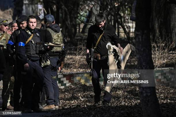 An Ukranian serviceman carries a downed Russian drone in the area of a research institute, part of Ukraine's National Academy of Science, after a...