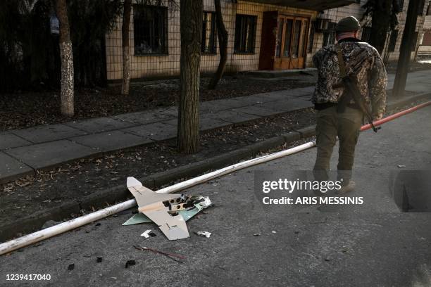 Ukranian serviceman stands next to a downed Russian drone in the area of a research institute, part of Ukraine's National Academy of Science, after a...