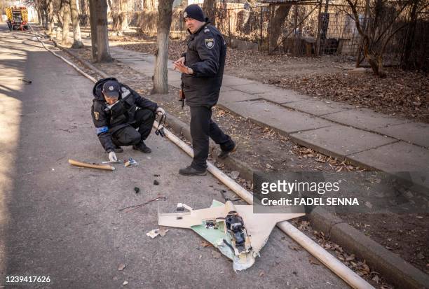 Ukrainian police officers inspect a downed Russian drone in the area of a research institute, part of Ukraine's National Academy of Science, after a...