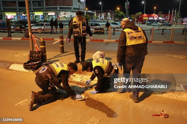 Zaka volunteers, an Ultra-Orthodox Jewish emergency response team in Israel, clean up blood stains at the scene of a car-ramming attack outside a...