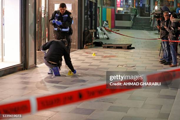 Israeli police cordon off the scene of a knife attack outside a shopping centre in the southern city of Beersheba, on March 22, 2022. - A knife and...