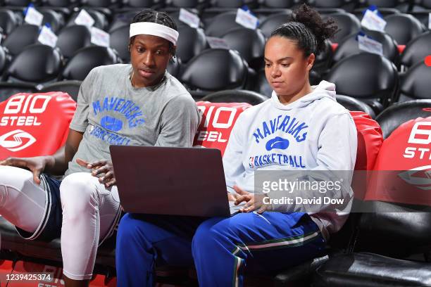 Frank Ntilikina of the Dallas Mavericks talks with assistant coach Kristi Toliver during warm up before the game against the Philadelphia 76ers on...