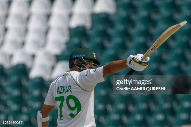 Pakistan's Azhar Ali celebrates after scoring a half-century during the third day of the third cricket Test match between Pakistan and Australia at...