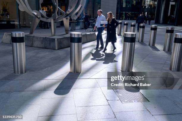 Workers walk through sunlight in Lime Street where many financial servioces and insurance companies have their headquarters in the City of London,...