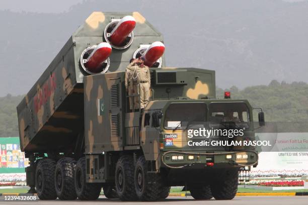 Pakistani army soldiers salute from a atop a military vehicle carrying missiles Babur during the Pakistan Day parade in Islamabad on March 23, 2022.