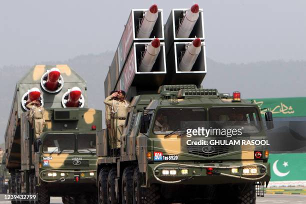 Pakistan's army soldiers salute from atop military vehicles carrying missiles Nasr and Babur during the Pakistan Day parade in Islamabad on March 23,...