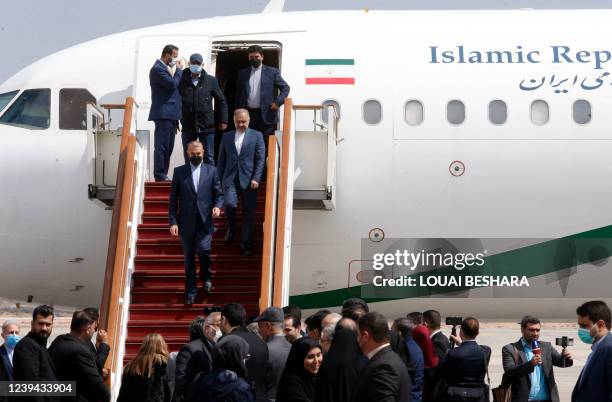 Iran's Foreign Minister Hossein Amir-Abdollahian walks down from his official aeroplane at the tarmac of Damascus' airport as he arrives with a...