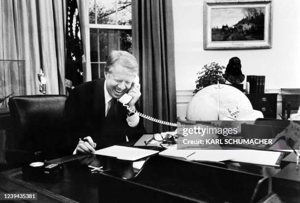 Photo taken in 1978 shows US President Jimmy Carter phoning at his desk at the White House in the Oval Office in Washington.