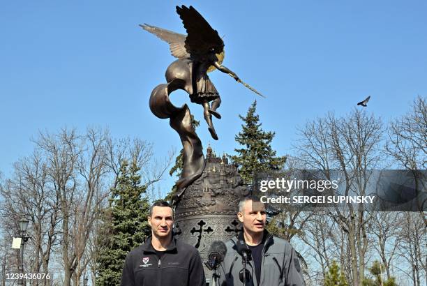 Kyiv's mayor Vitali Klitschko addresses a press conference in front of monument dedicated the the city's protector Archangel Gabriel with his brother...