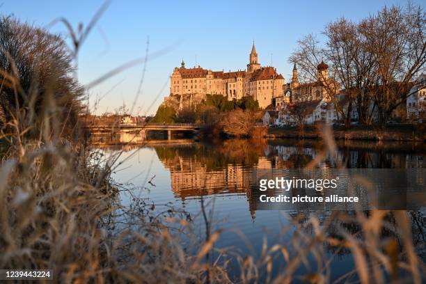 March 2022, Baden-Wuerttemberg, Sigmaringen: Sigmaringen Castle, also called Hohenzollern Castle, is reflected in the Danube in the evening. Photo:...