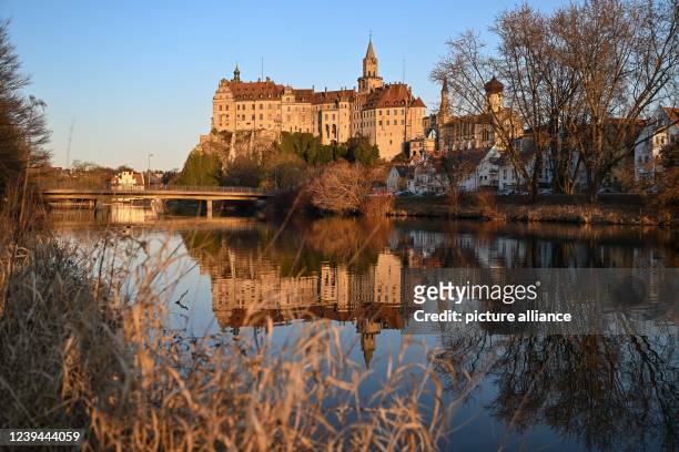 March 2022, Baden-Wuerttemberg, Sigmaringen: Sigmaringen Castle, also called Hohenzollern Castle, is reflected in the Danube in the evening. Photo:...