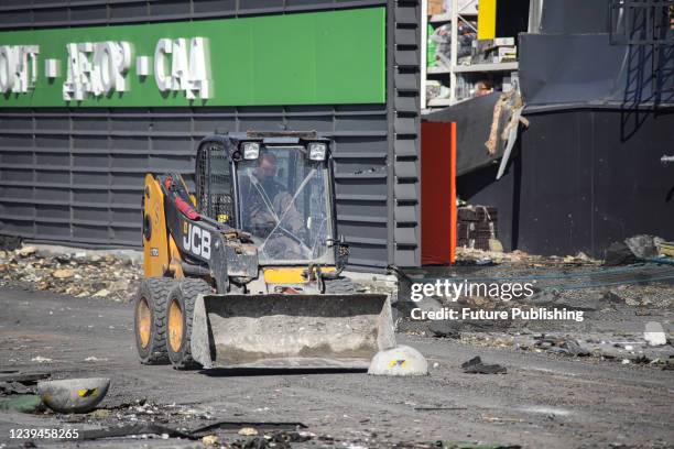 Driver operates a bucket loader to remove rubble from the premises of a shopping mall ruined as a result of a missile strike carried out by the...